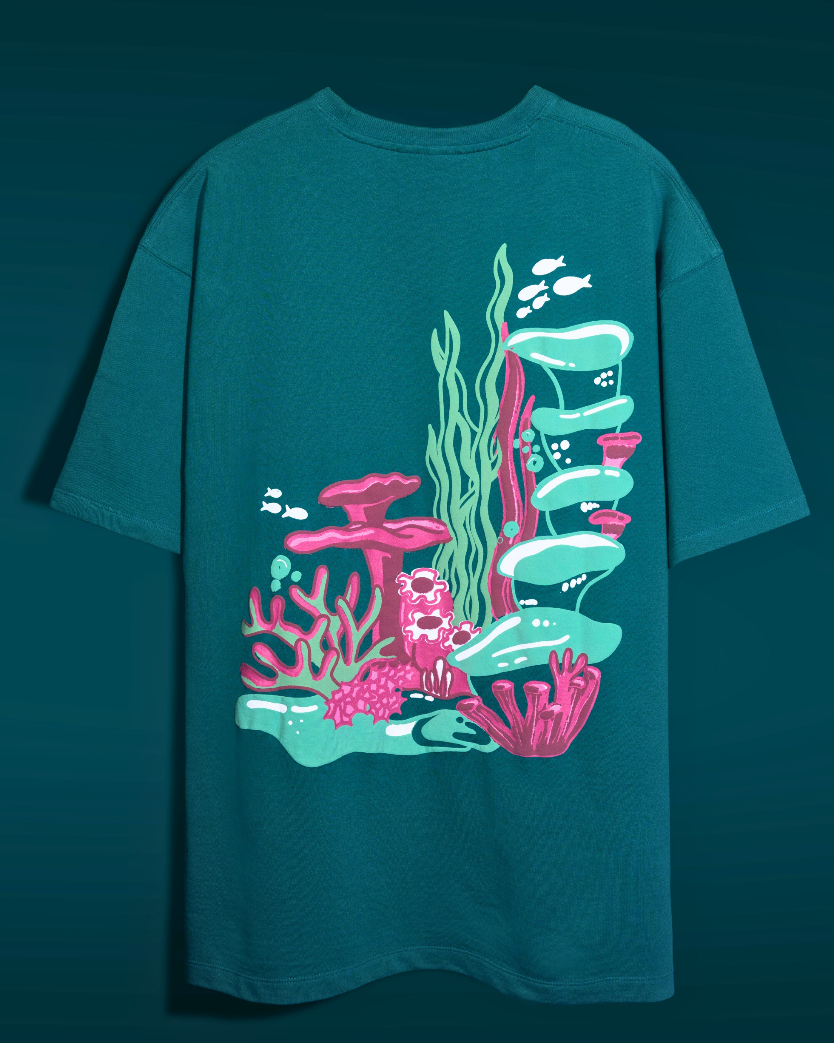 Teal t-shirt with colorful underwater scene design on a dark teal background