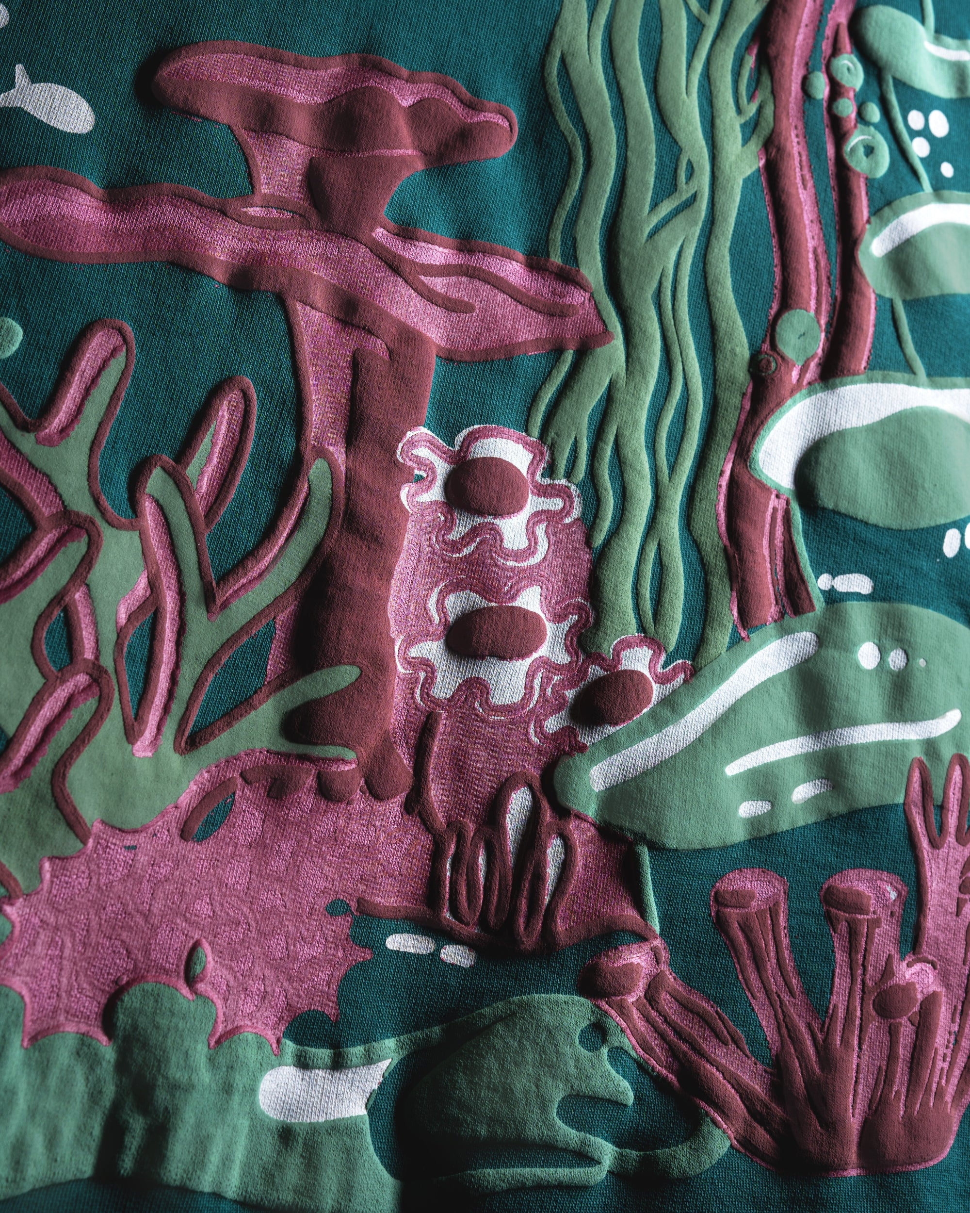 Close-up of a textured fabric with underwater-themed design featuring fishes and coral.